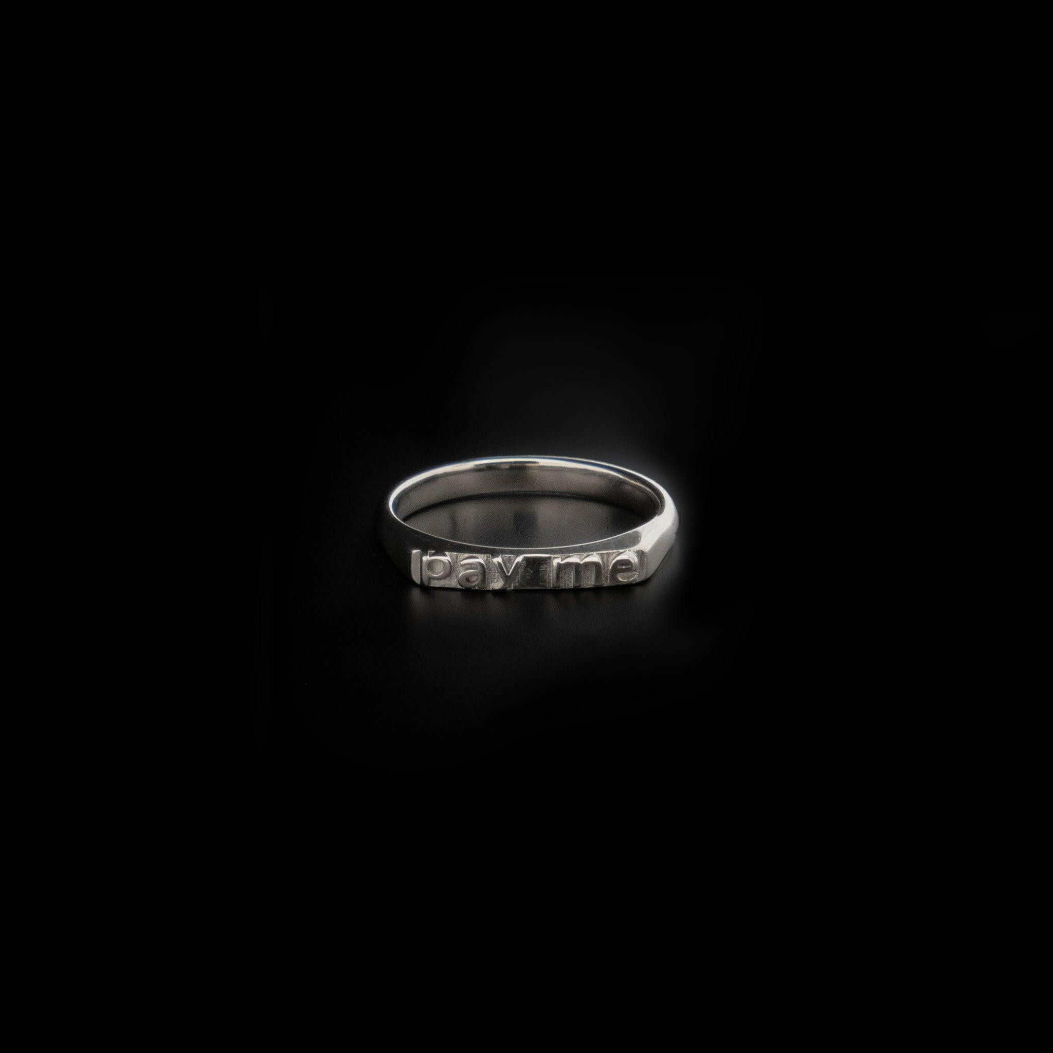 front view of sterling silver ring with text that reads "pay me"
