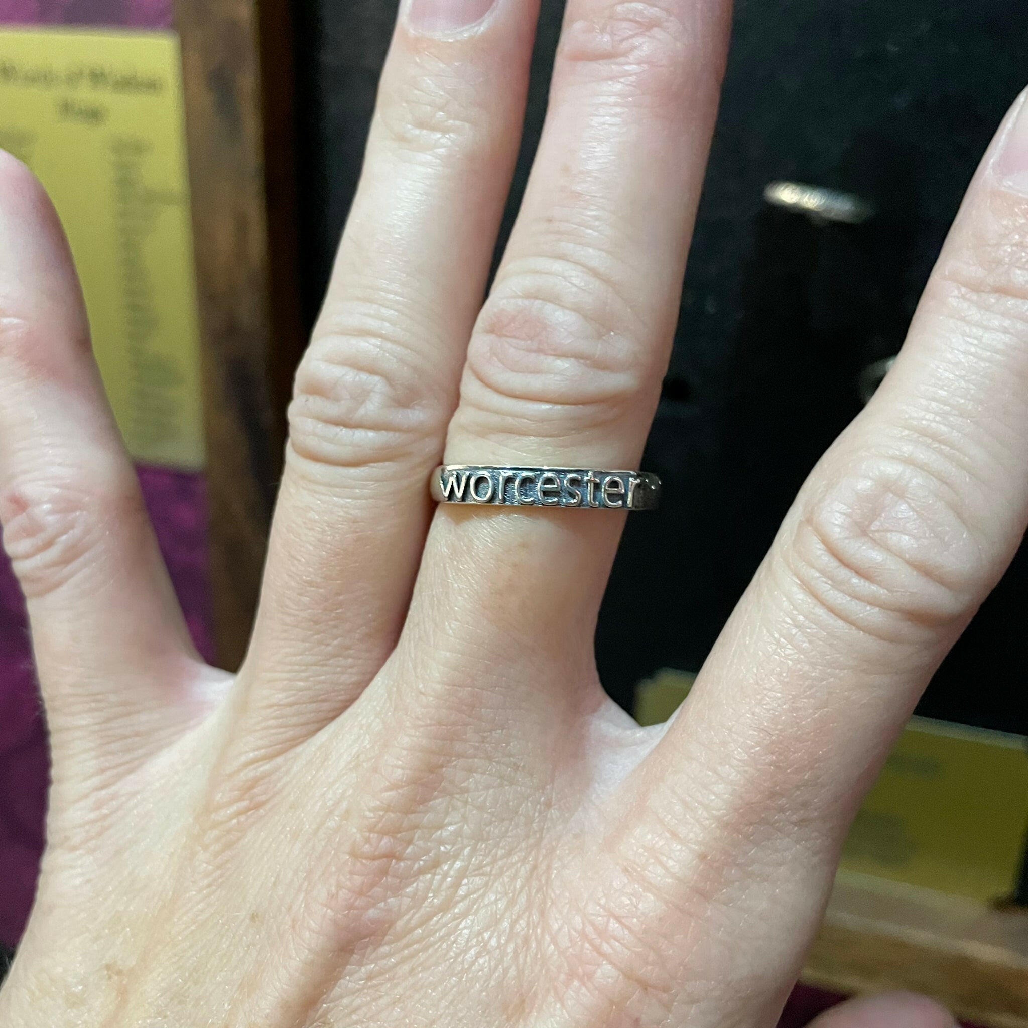 hand wearing a sterling silver ring with text that reads "Worcester"