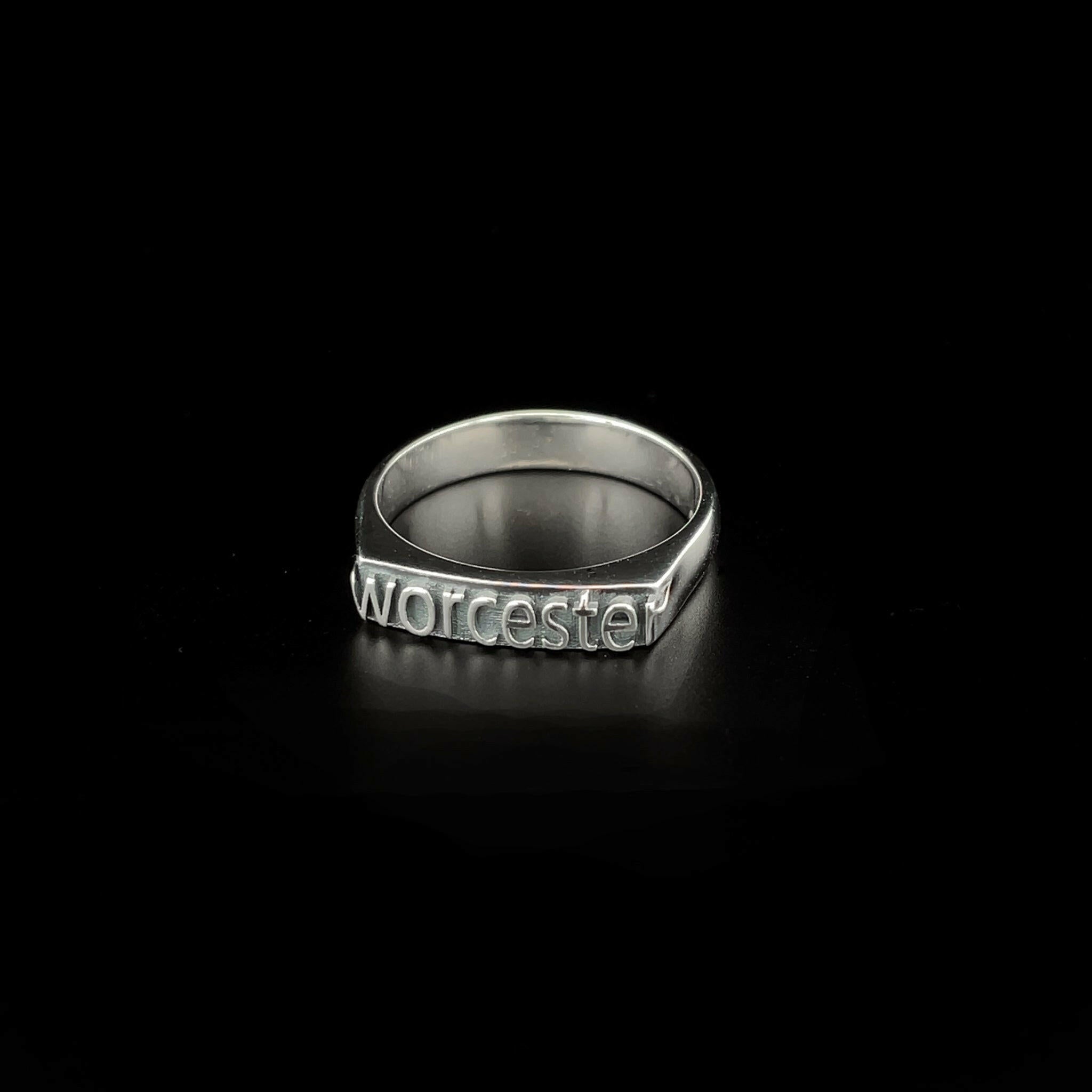 slightly right angled sterling silver ring with text that reads "Worcester"