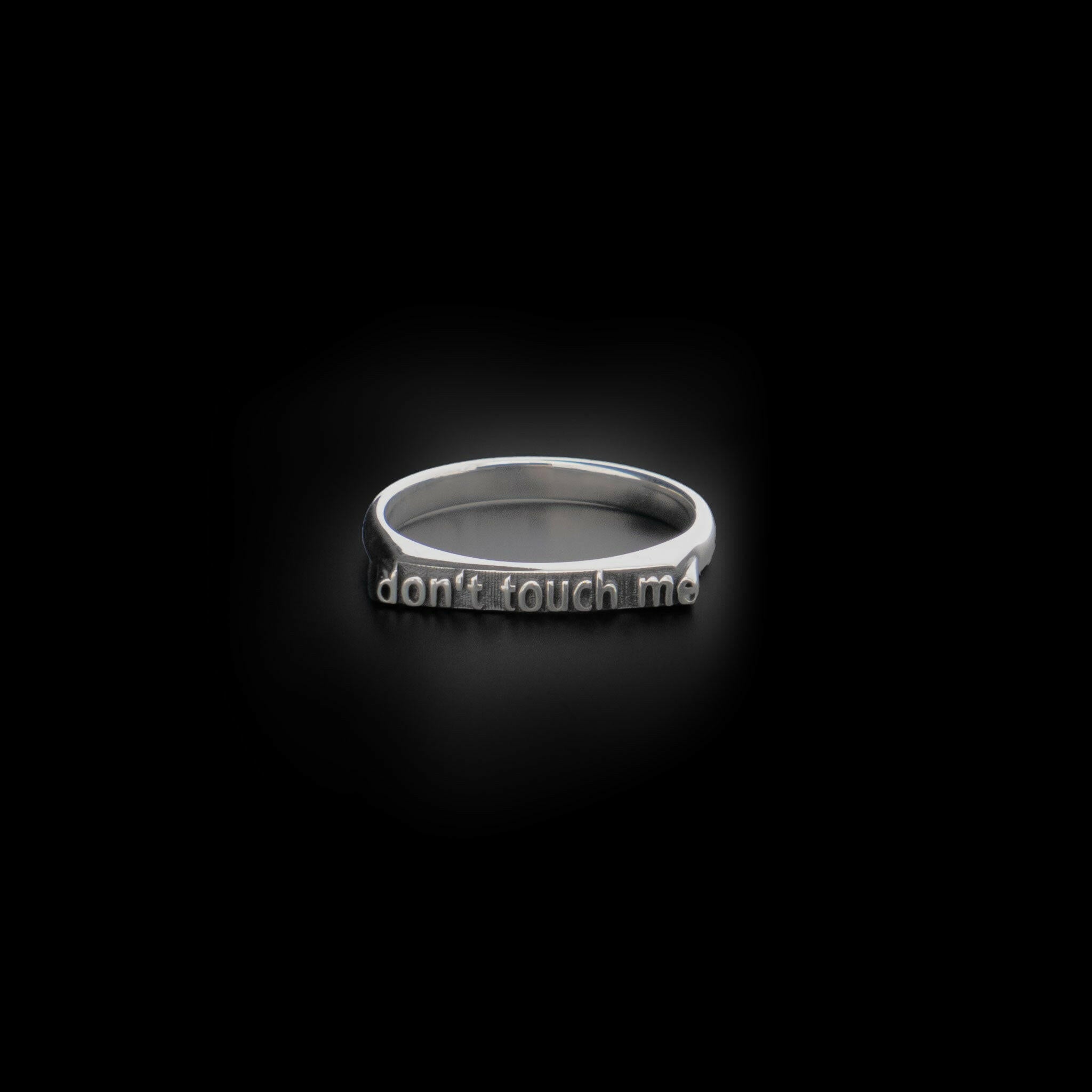 front view of sterling silver ring with text that reads "don't touch me"