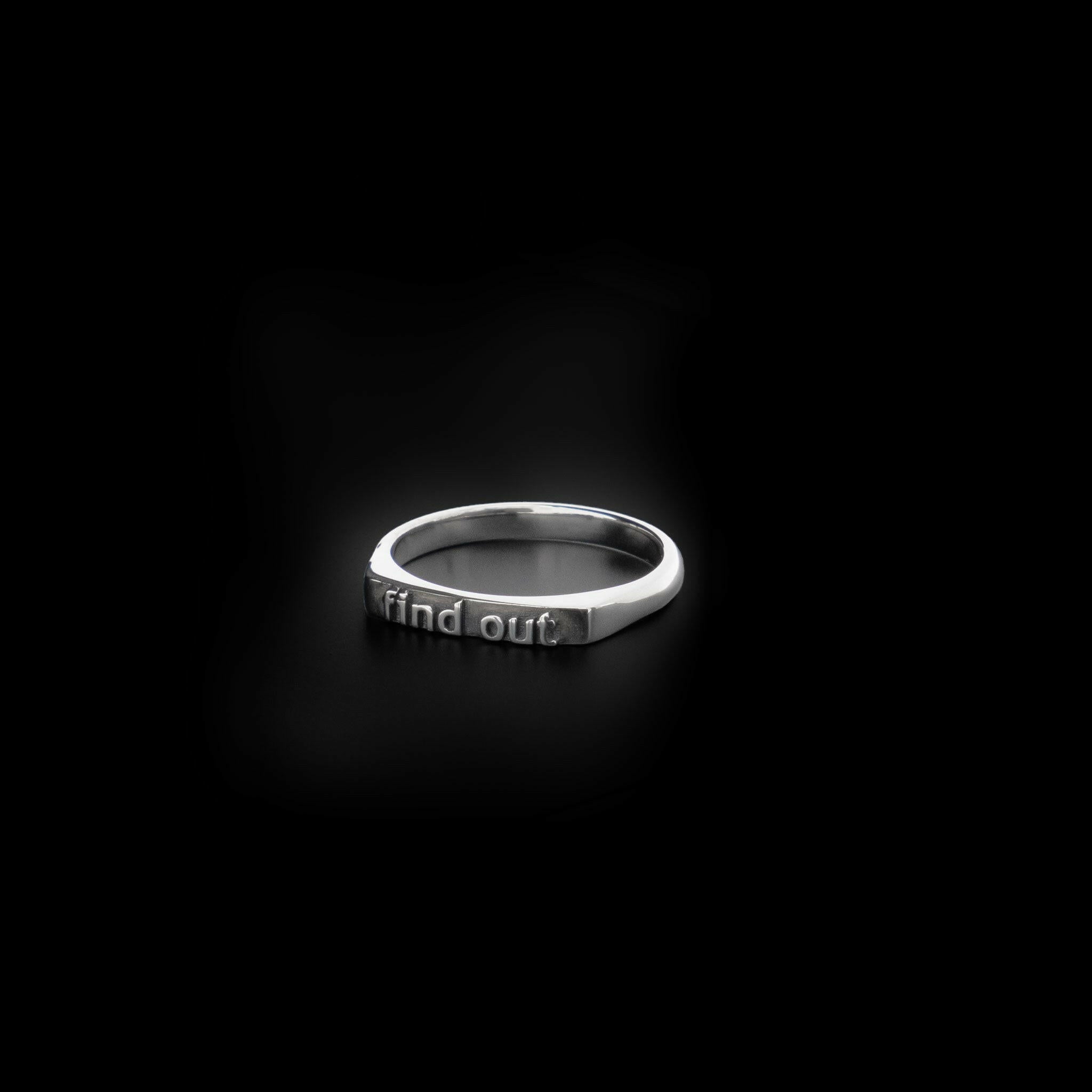 right angle view of a sterling silver ring with text reading "find out"