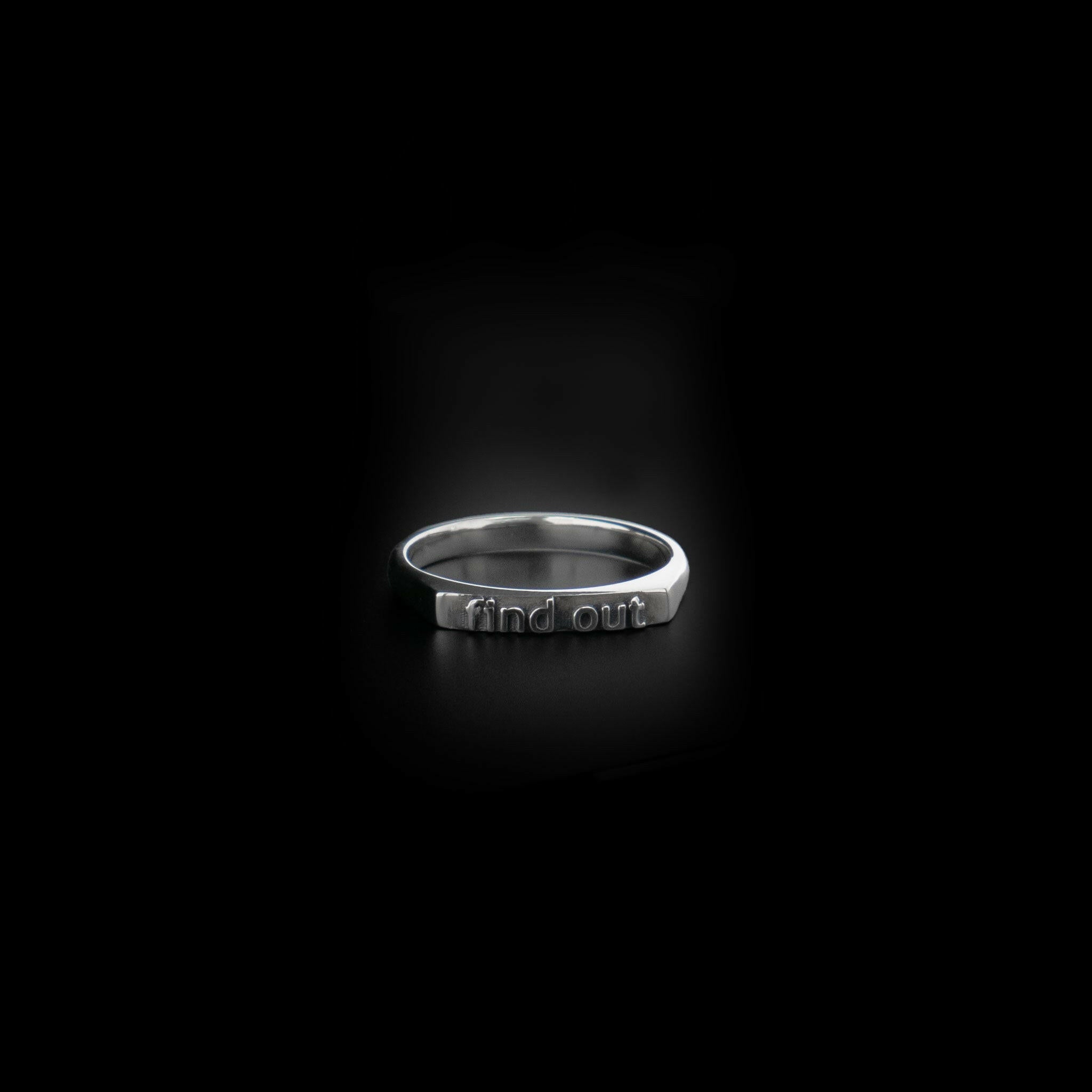 front view of a sterling silver ring with text saying "find out"