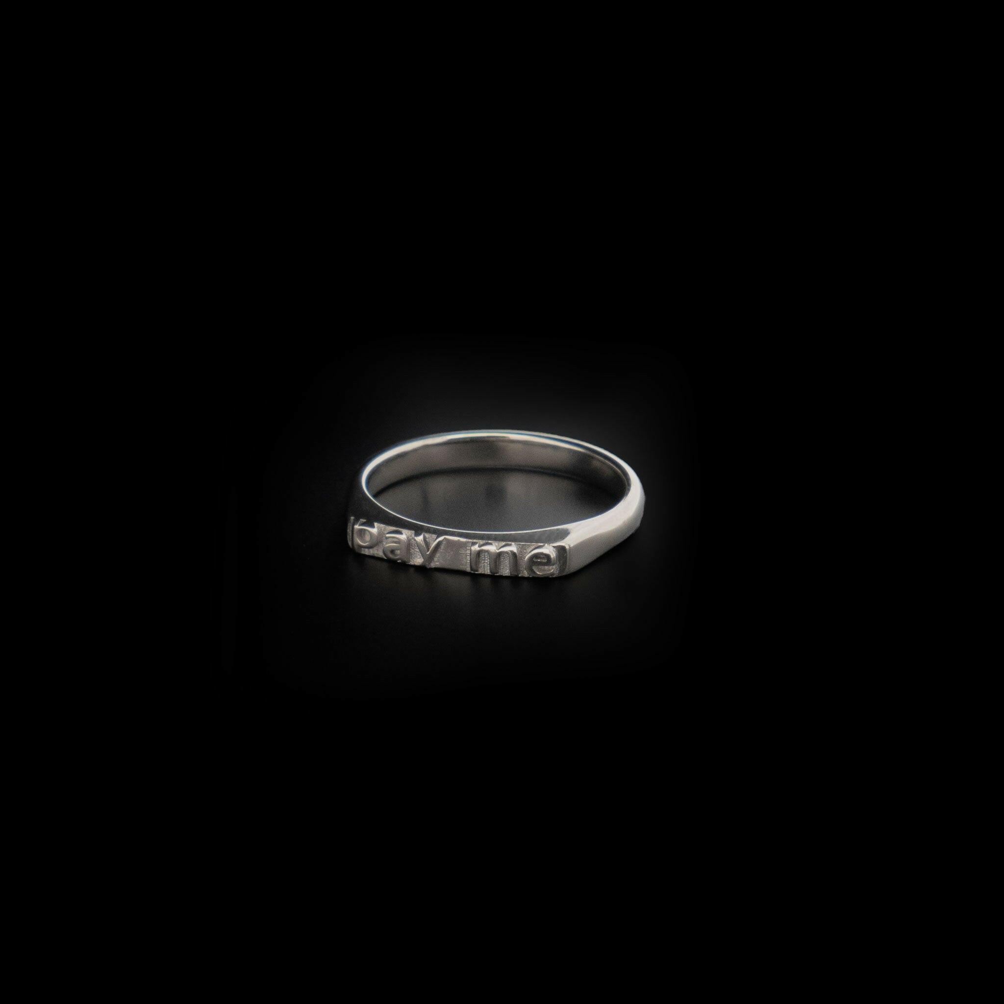 slightly right angled ring with texts that reads "pay me"