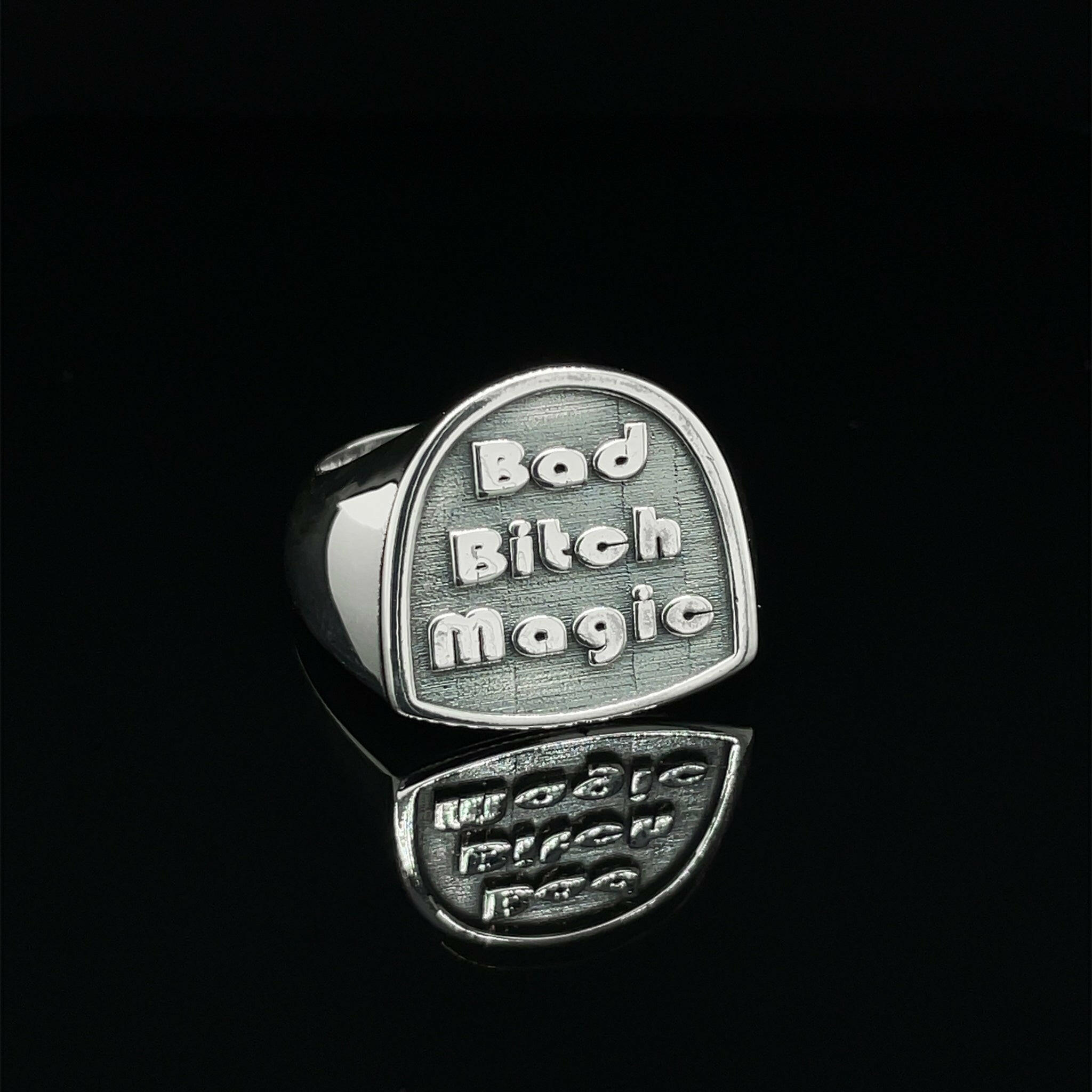 front left angle of sterling silver ring that reads "bad bitch magic"
