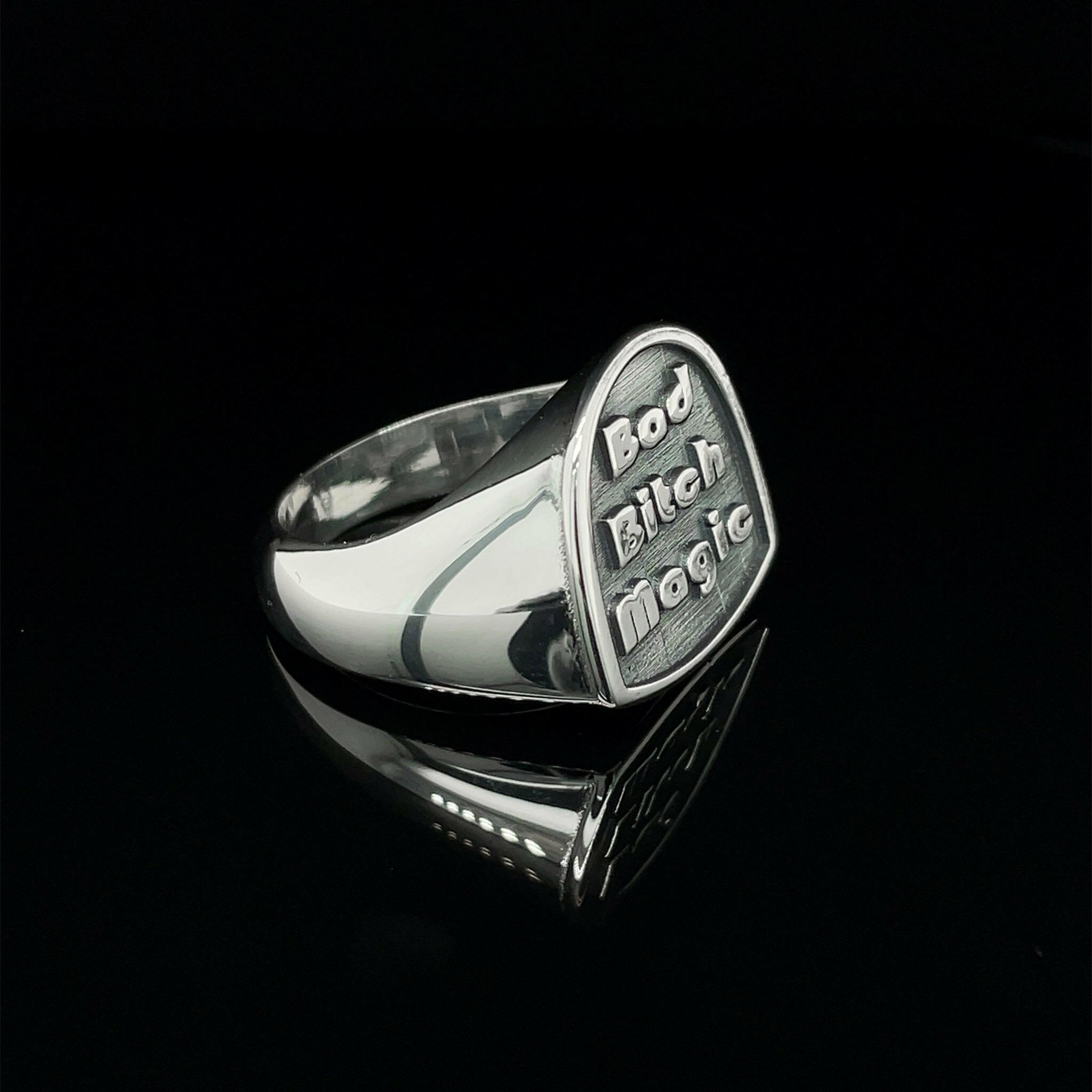 front left side of sterling silver ring reads "bad bitch magic"