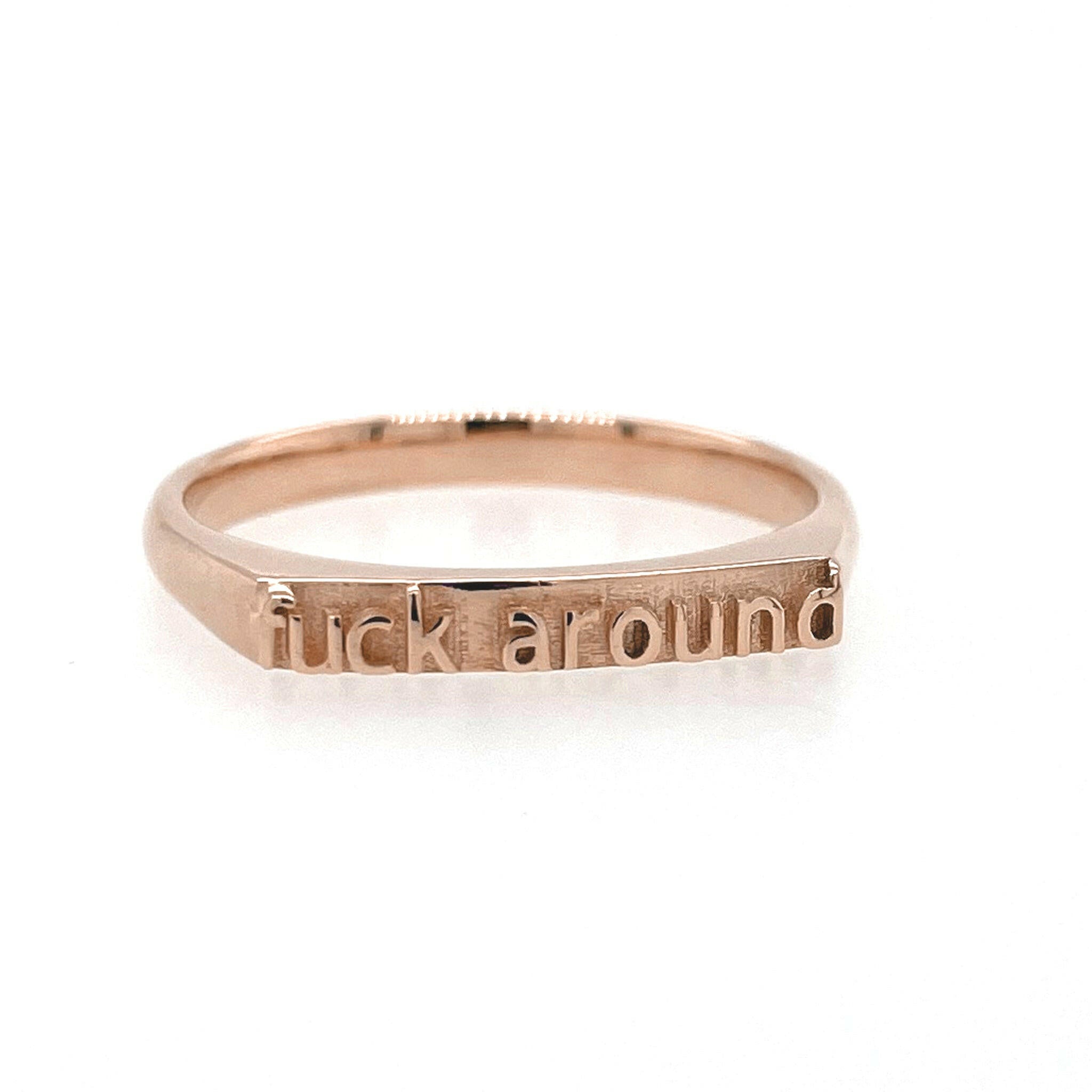 Front view of 14 Karat Rose Gold ring that reads "fuck around" in text.