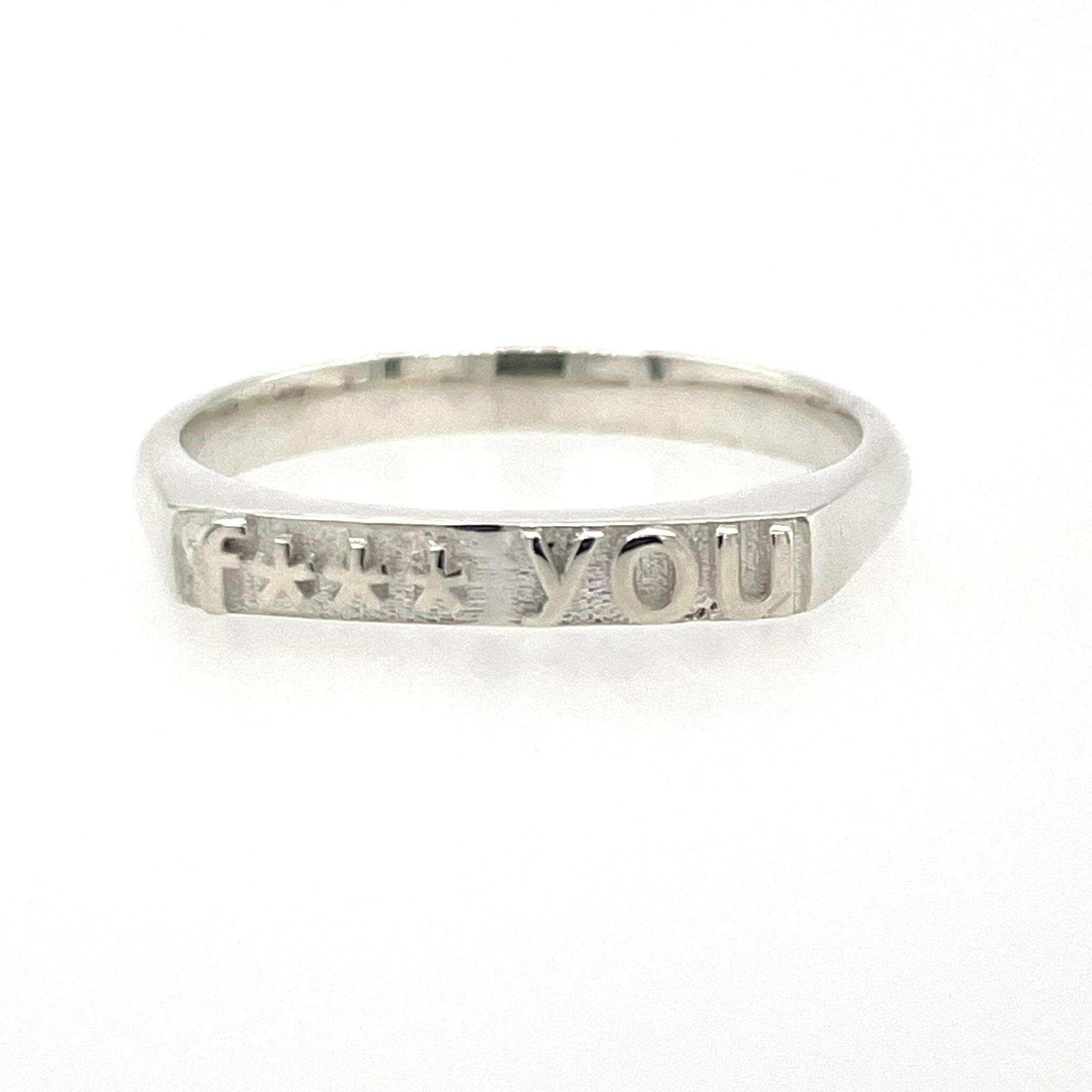 front view of ring in 14 karat white gold with text that reads "fuck you" but with 4 asterisks to censor fuck, therefore says "f*** you"