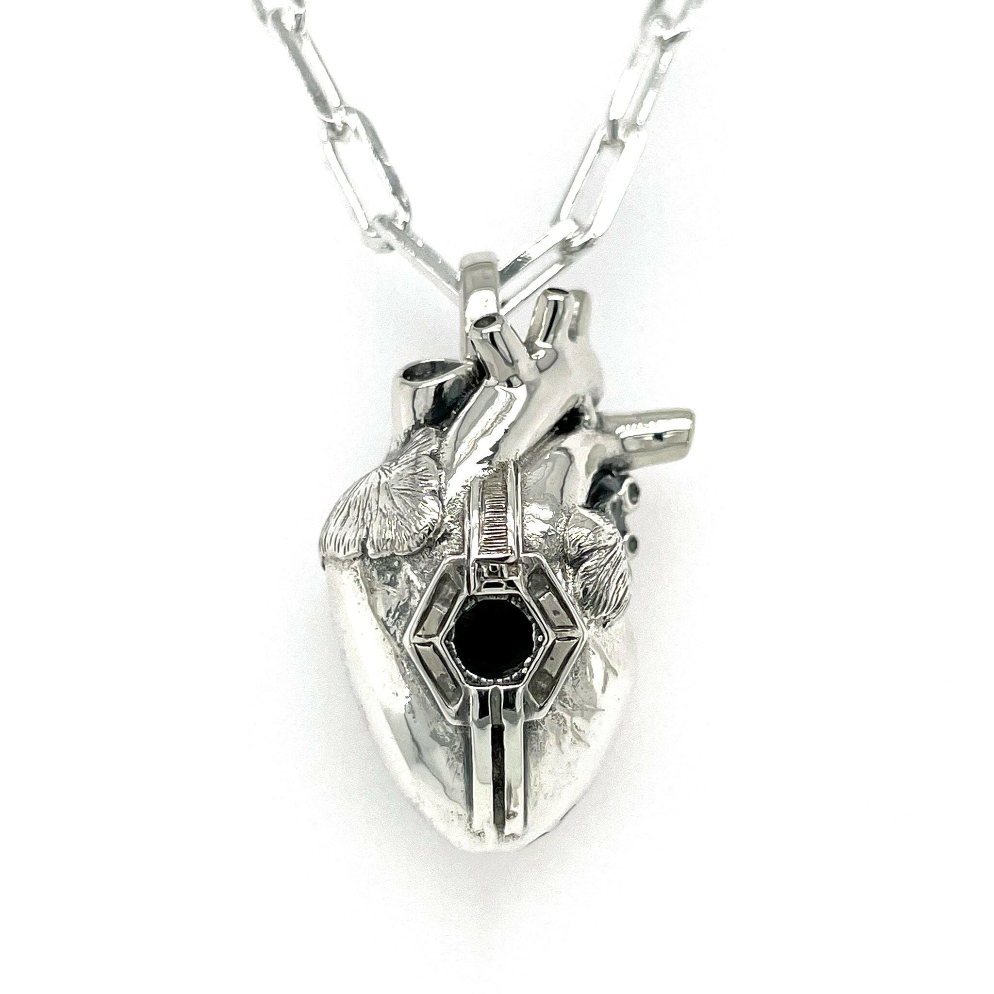 Front view of fatal flaw pendant made of sterling silver , pendant resembles an atomical heart with a hexagonal hole in the center.