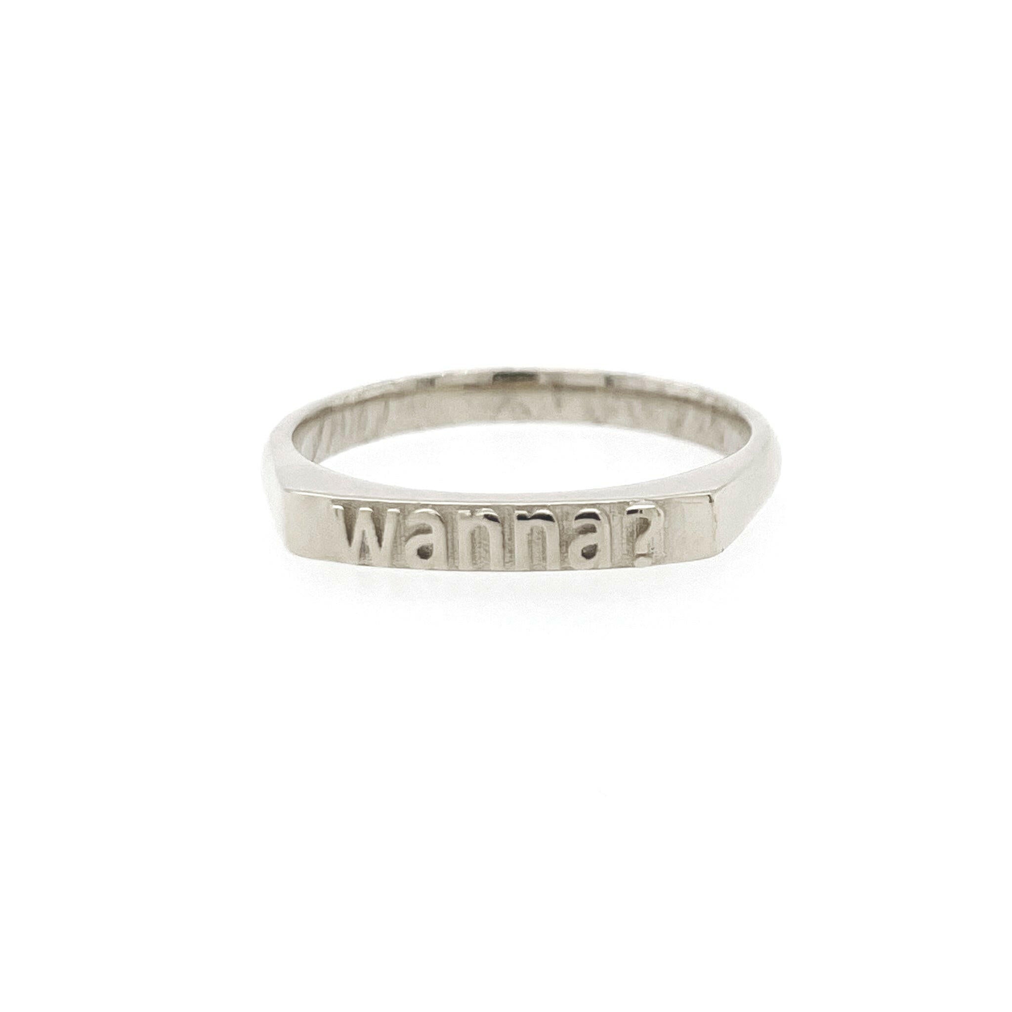 front view of  14 karat white gold with text that reads "wanna?"